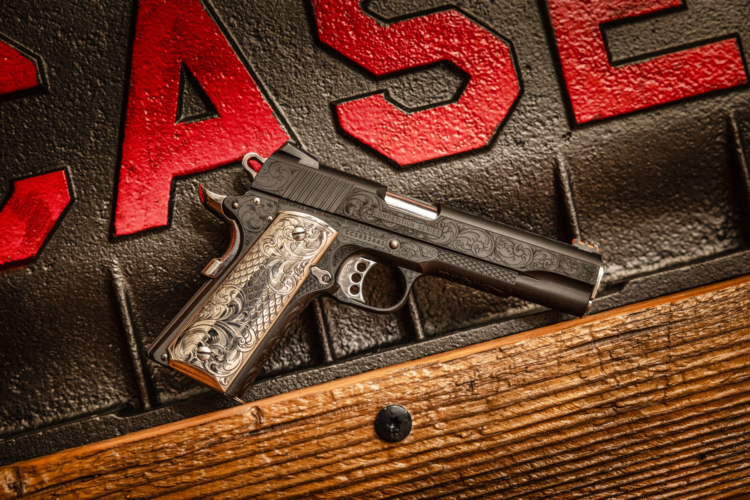 Deep-engraved 1911 on wood shelf with dark brick background